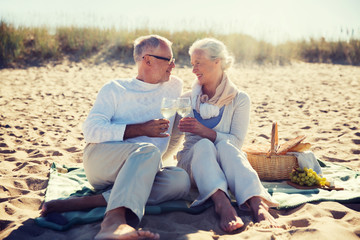 happy senior couple talking on summer beach