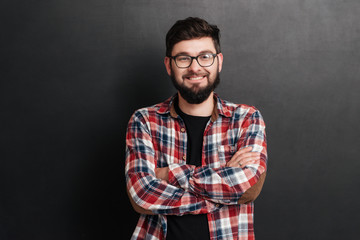 Happy man standing over chalkboard with arms crossed