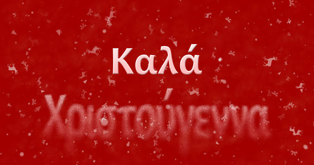 Merry Christmas text in Greek turns to dust from bottom on red background