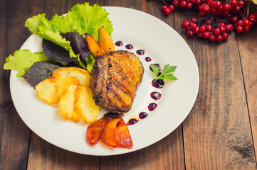 Duck breast with potato chips, herbs, sauce and caramelized apples. Wooden rustic table. Top view. Close-up