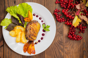Duck breast with potato chips, herbs, sauce and caramelized apples. Wooden rustic table. Top view. Close-up