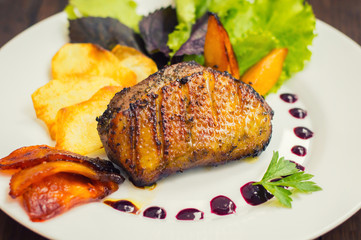 Duck breast with potato chips, herbs, sauce and caramelized apples. Wooden rustic table. Top view. Close-up