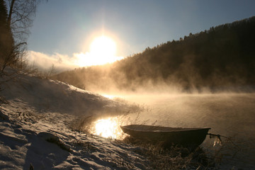 Lonely boat in a frozen lake Bay.