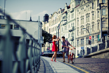 Couple in Red Walking on the Street with Bike in old town in Pra