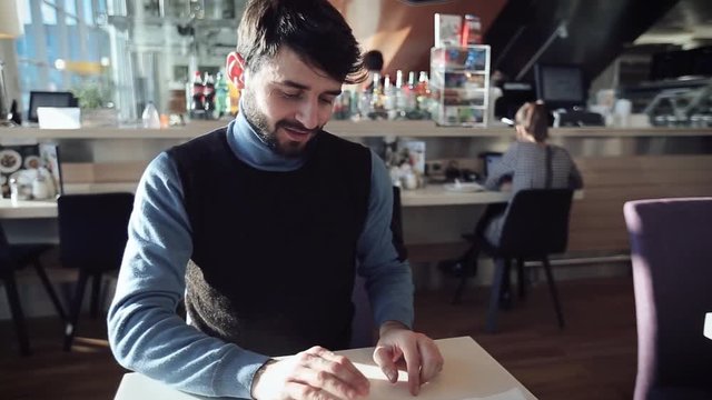  A young man a paid for online shopping with a bank card and he  is happy and smiles