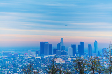 Airplane flying over downtown Los Angeles at dawn