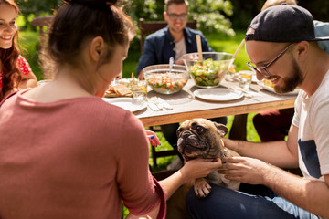 happy friends having dinner at summer garden party