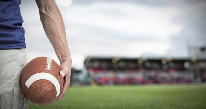 Composite image of midsection of sports player holding ball