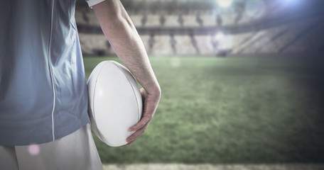 Composite image of serious rugby player with arms crossed