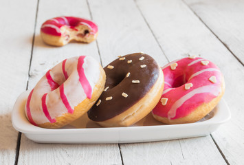 Colorful glazed  donuts on wooden table