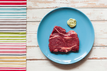 Raw steak on wooden table