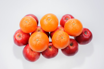 Red apples and oranges on white background