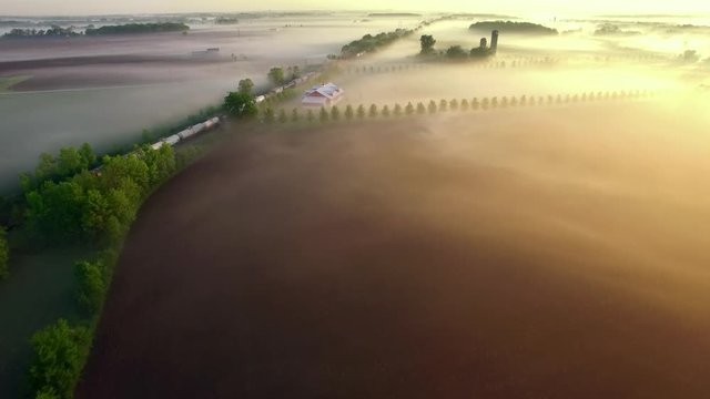 Freight train rolls across breathtakingly beautiful, foggy landscape at sunrise. Some of the best, most visually stunning train footage you’ll ever find.