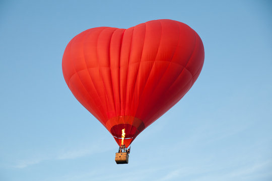 Heart shaped balloon. A journey for lovers. Aerostat against the blue sky.