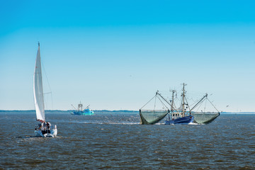 Obraz premium Fischkutter und Segelyacht
