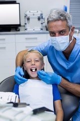 Dentist examining a young patient with tools