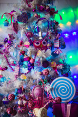 The colorful Christmas tree stands in the center of room