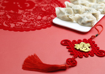Spring Festivl dumplings and paper-cut on red background