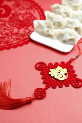 Spring Festivl dumplings and paper-cut on red background