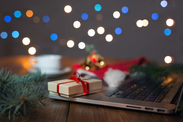 Fototapeta na wymiar Greetings throw Internet Gift Box Computer and Christmas Lights