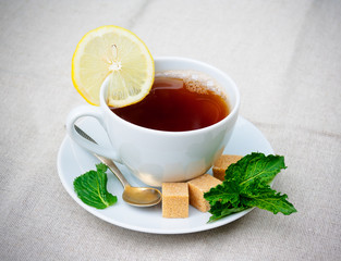 Tea with mint, brown sugar and lemon on  table. Selective focus
