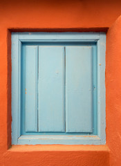 Obraz na płótnie Canvas a blue wooden door or shutter in an orange wall