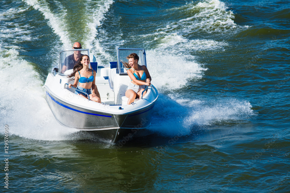 Wall mural  Girls ride on the boat to drift