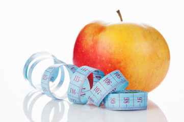 blue measure tape and red apple
