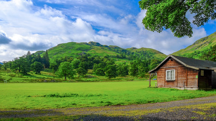 Green field and mountain with urban house in UK.