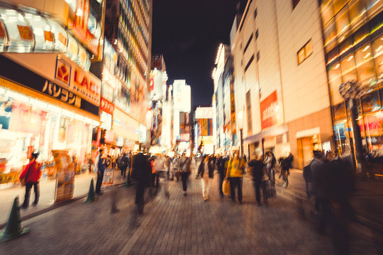 blur crowds moving on a major shopping area for electronic, computer, anime, games and manga (otaku) goods in  Akihabara, Tokyo, Japan. vintage photo and film style.
