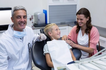 Mother and son talking while dentist examining