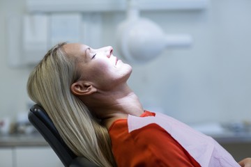 Woman relaxing on dentist chair - Powered by Adobe