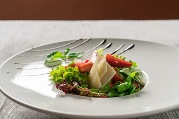Salad greens, cheese and strawberries with balsamic sauce.