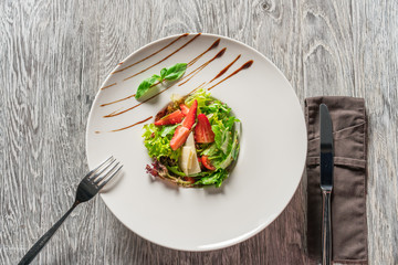 Salad greens, cheese and strawberries with balsamic sauce.