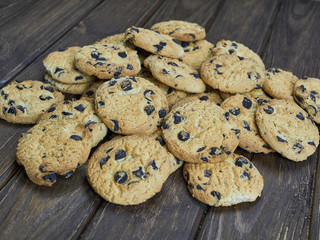 Homemade chocolate chip cookies on dark brown wooden background