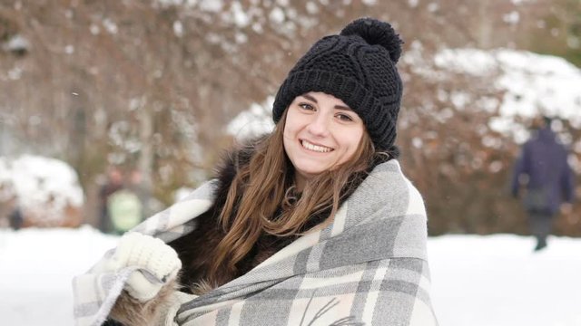 Portrait of pretty girl smiling to the camera in windy cold day. Slowly