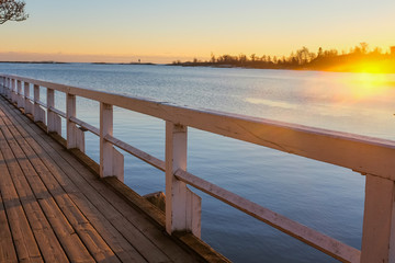 Wooden footbridge to sea at sunset. Kaivopuisto park, Helsinki, Finland.
