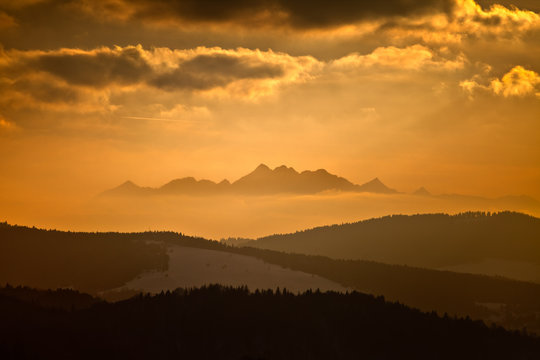 Fototapeta Zachód słońca zimą w górach w mieście górskim Muszyna. Widok na Tatry  