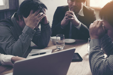 Team of unhappy businesspeople sitting in business meeting./stra