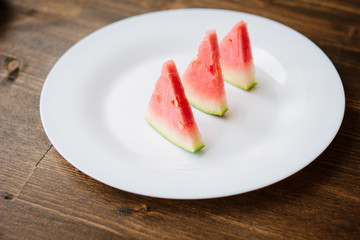 Small pieces of watermelon on white plate.