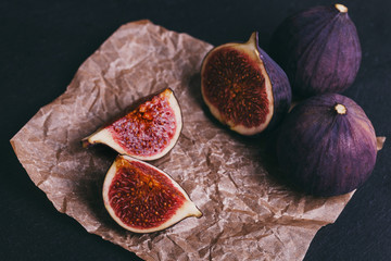figs on a dark wood background. tinting. selective focus on the front figs slice in the bowl
