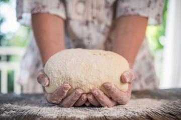 Woomens hands holding a finished clean dough