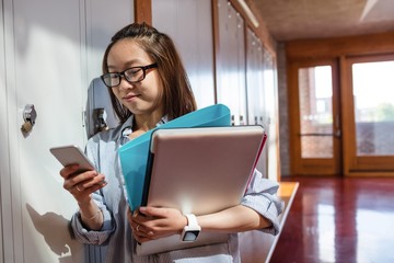 Young woman using mobile phone in locker room