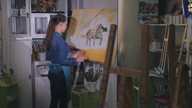 female artist working on a painting. slow-motion