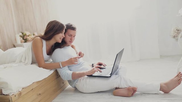 happy couple with laptop and card to buy online at home