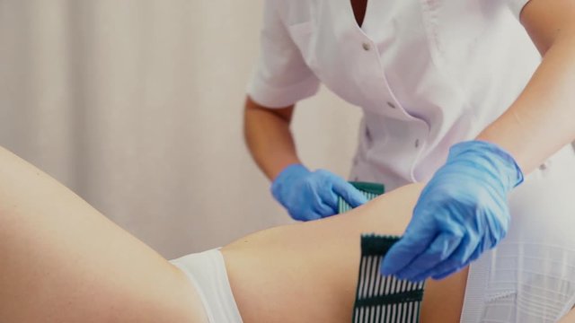 Female belly piercing in the navel. Woman on hardware cosmetology procedures. clinic staff prepare the client for the procedure. Preparations for mesotherapy procedure.