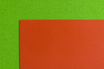 Fototapeta premium Eva foam ethylene vinyl acetate smooth orange surface on apple green sponge plush background