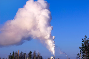 Industrial smoke from chimney on blue sky