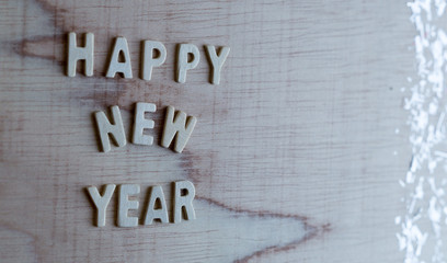 Wooden white "Happy new year" with christmas decor on wooden background.