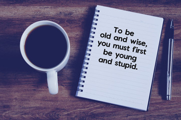 Top view of coffee, notepad and pen on a wooden table, retro sty